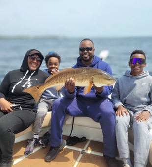 Happy family with a solid redfish catch.